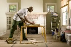 A man cutting wood for a renovation